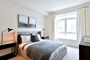 a bedroom with a bed and a large window